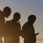 silhouette of men on mobile phones