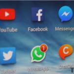 Phone screen showing various social media apps, WhatsApp included