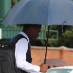 Man holding umbrella walking.