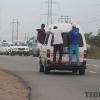 Commuter omnibus with people hanging at the back