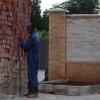 Builder next to bricks near a wall